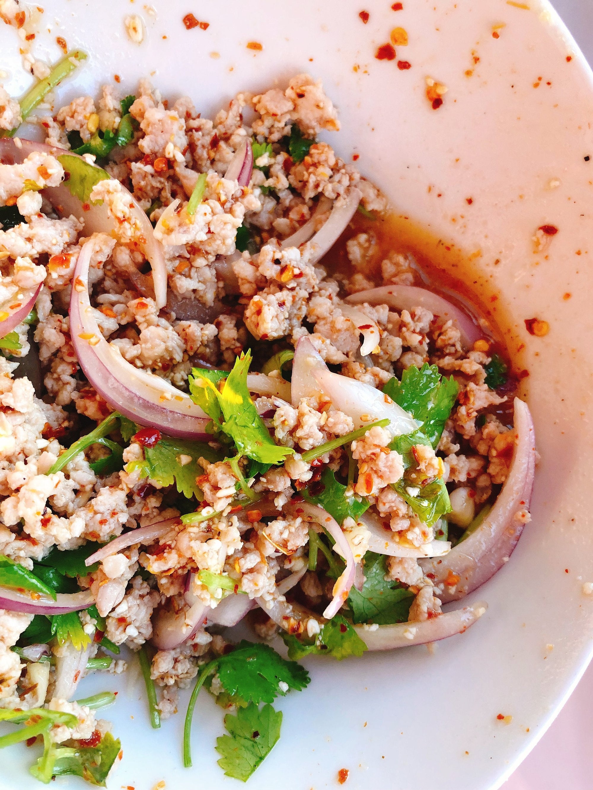Close-up of Thai laab, a minced meat salad tossed with herbs, lime, chilies, shallots, and toasted rice powder.